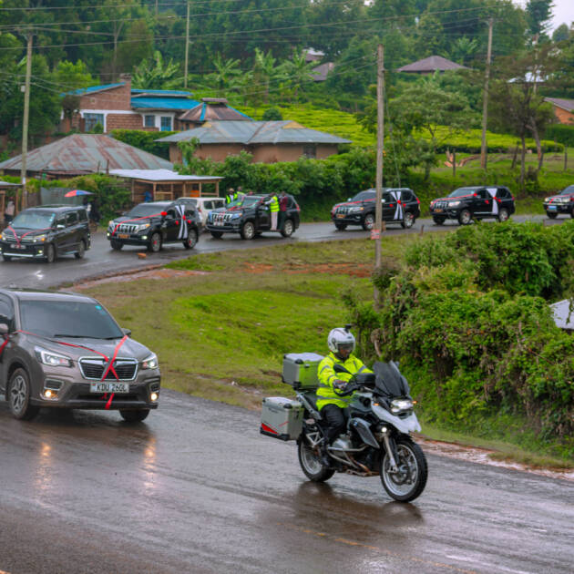Professional outrider in high-visibility gear on a silver and black BMW R 1200 RT Presidential escort motorcycle.
