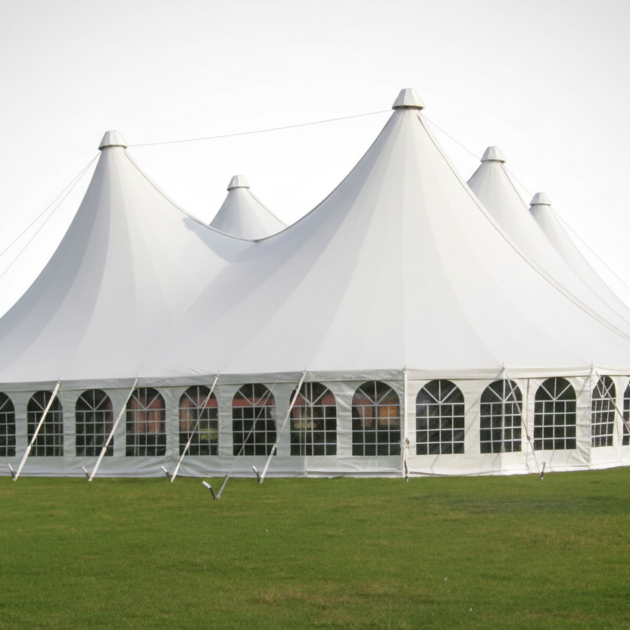 Large white executive alpine dome tent with multiple peaks and arched windows set on a green lawn.